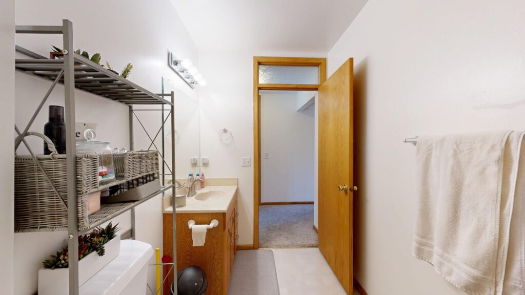 Bathroom with open wall shelves used for towels and toiletries.